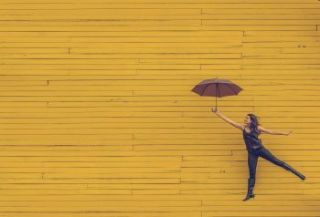 woman dancing with umbrella looks free