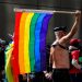 man waving flag in pride parade