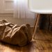 brown duffel bag beside white and brown wooden chair