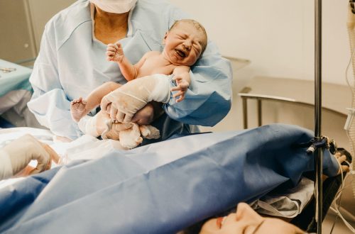 shallow focus photo of person carrying topless baby