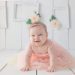 girl crawling on white floor while smiling