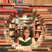 woman in green shirt sitting on books