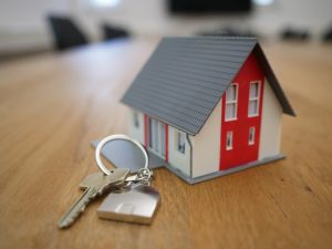 Gratitude for home. white and red wooden house miniature on brown table